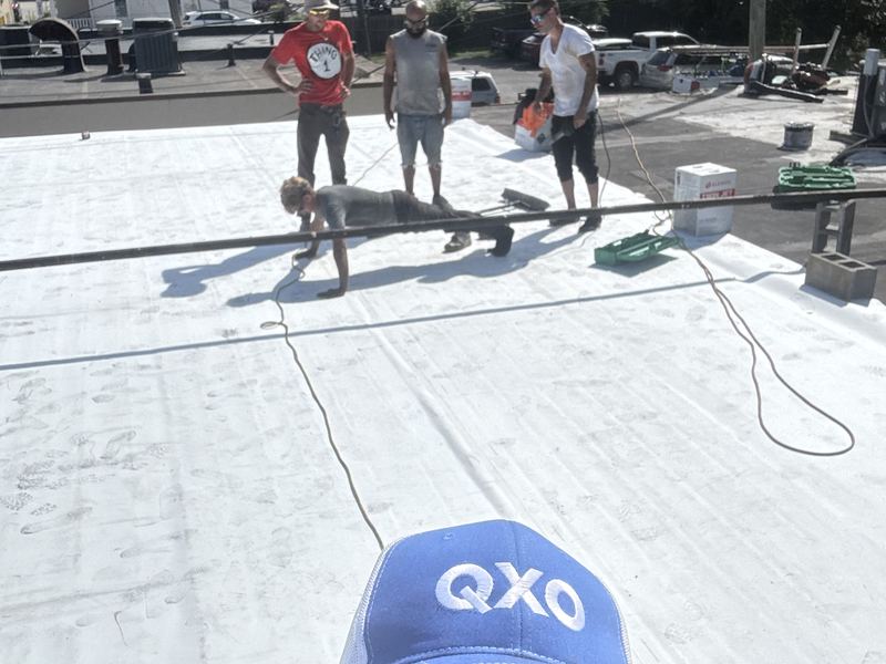 Completed white flat roof with the crew